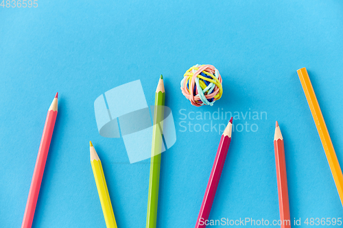 Image of coloring pencils and rubber bands on blue