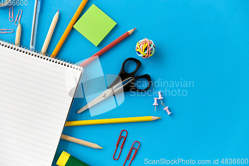 Image of notebook and school supplies on blue background