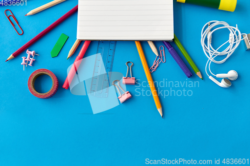 Image of notebook and school supplies on blue background