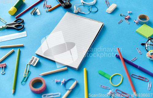 Image of notebook and school supplies on blue background