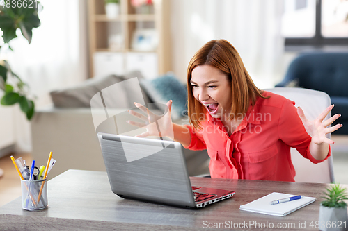 Image of angry woman with laptop working at home office