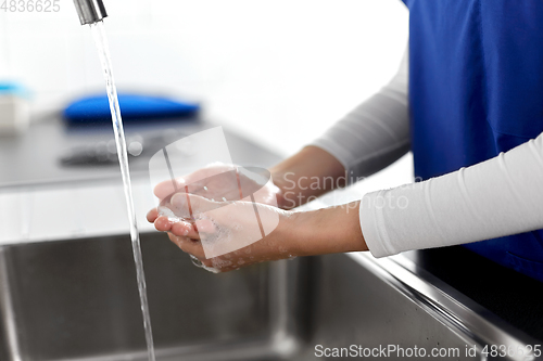 Image of doctor or nurse washing hands with liquid soap