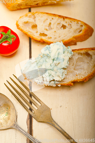 Image of fresh blue cheese spread ove french baguette