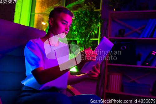 Image of Cinematic portrait of handsome young woman in neon lighted interior