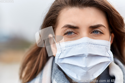 Image of young woman wearing protective medical mask