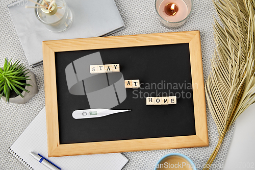 Image of chalkboard with stay at home words on toy blocks