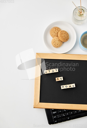 Image of chalkboard with stay at home words on toy blocks