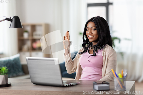 Image of woman with laptop having video call at home office