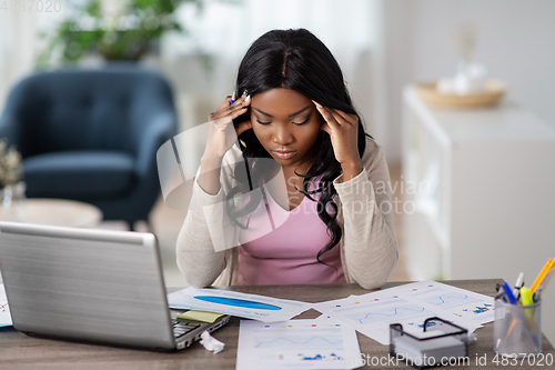 Image of stressed woman with papers working at home office