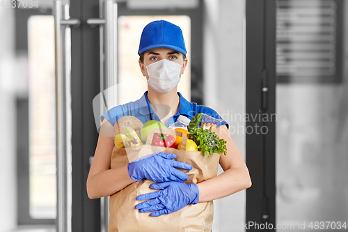 Image of delivery woman in face mask with food in paper bag