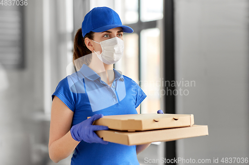 Image of delivery woman in face mask with pizza boxes