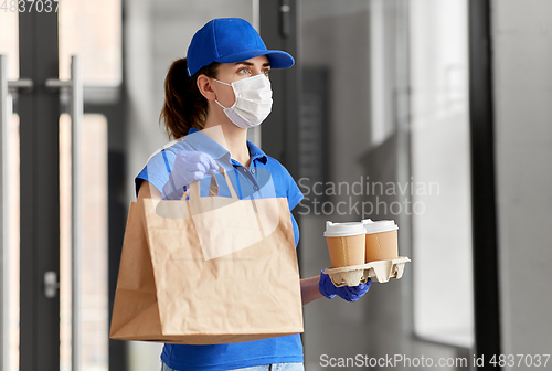 Image of delivery woman in face mask with food and drinks