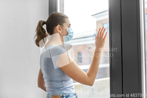 Image of sick young woman wearing protective medical mask