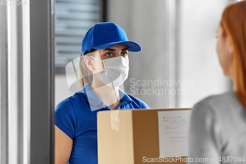 Image of delivery girl in face mask giving parcel to woman