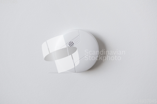 Image of smoke alarm, sensor or detector on white ceiling