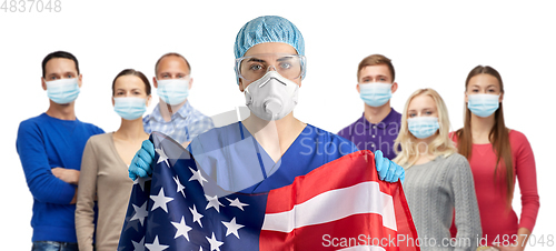 Image of doctor in goggles and mask holding flag of america