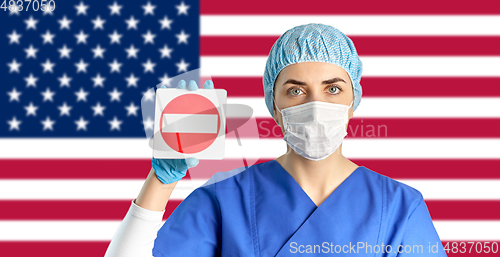 Image of american doctor or nurse in mask with stop sign