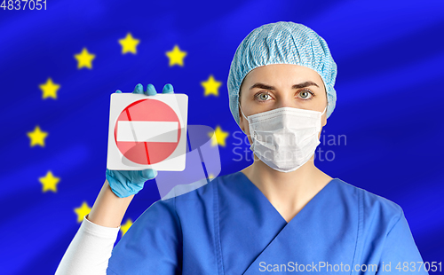 Image of european doctor or nurse in mask showing stop sign