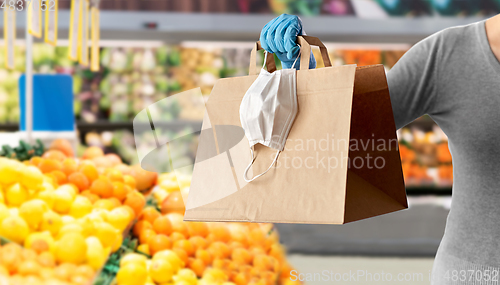 Image of woman with shopping bag, mask and glove at grocery