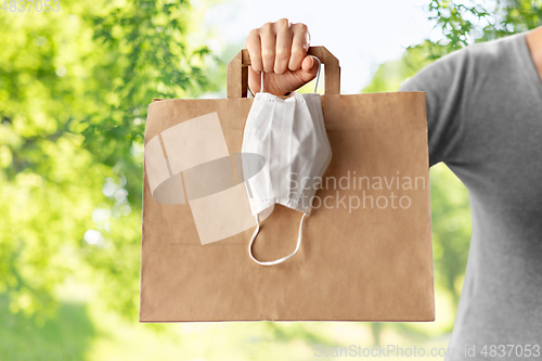 Image of woman with shopping bag, face mask and gloves