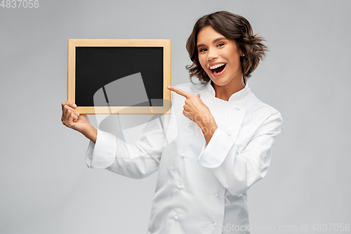 Image of smiling female chef holding black chalkboard