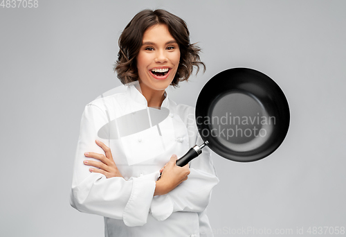 Image of smiling female chef in toque with frying pan