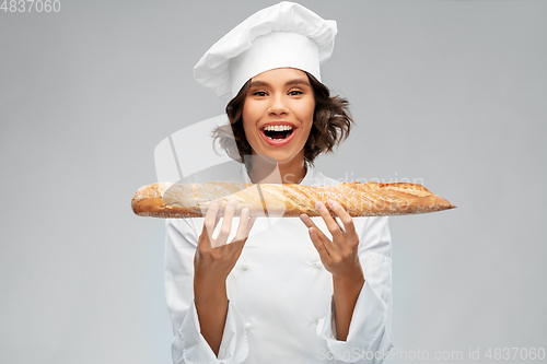 Image of happy female chef with french bread or baguette