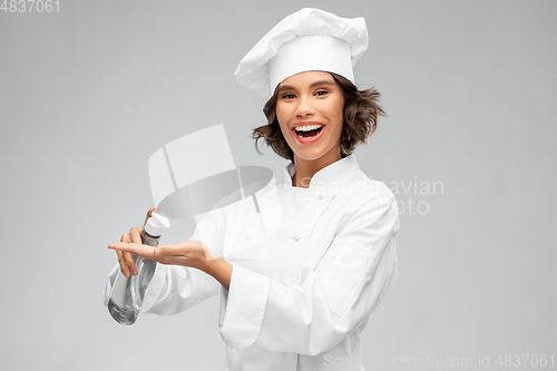 Image of female chef with hand sanitizer or liquid soap