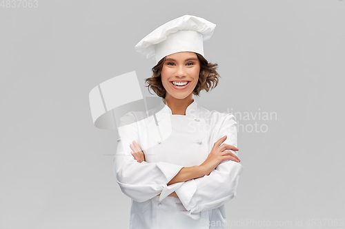 Image of smiling female chef in toque with crossed arms