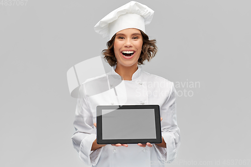 Image of smiling female chef in toque with tablet computer