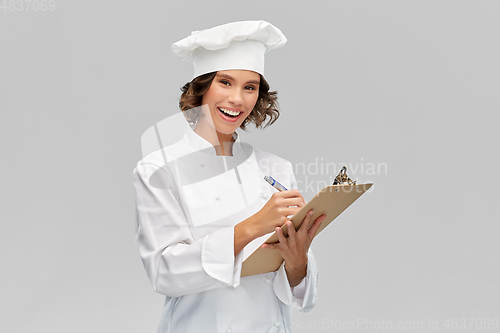 Image of smiling female chef in toque with clipboard