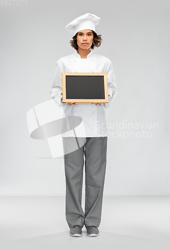 Image of female chef holding black chalkboard