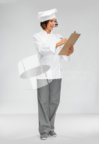 Image of smiling female chef in toque with clipboard