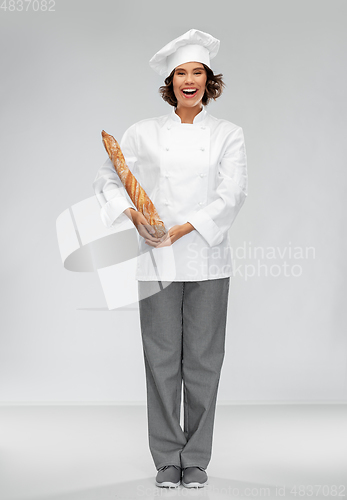 Image of happy female chef with french bread or baguette