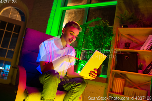 Image of Cinematic portrait of handsome young woman in neon lighted interior