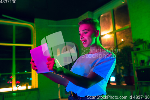 Image of Cinematic portrait of handsome young woman in neon lighted interior