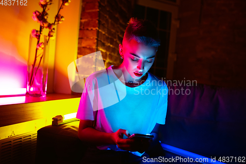 Image of Cinematic portrait of handsome young woman in neon lighted interior