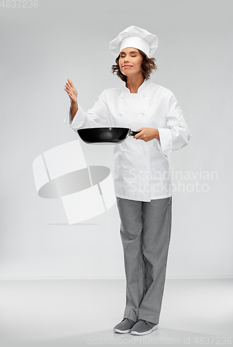 Image of female chef with frying pan smelling food flavor