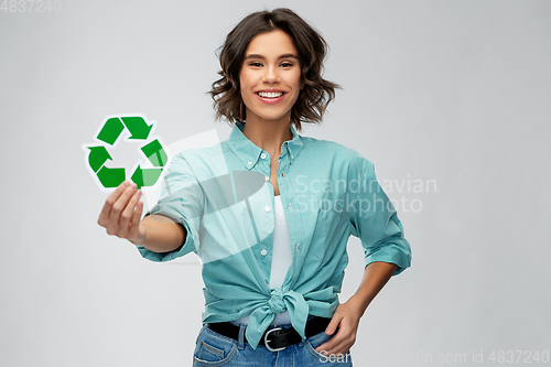 Image of smiling young woman holding green recycling sign