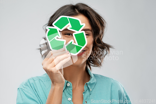 Image of smiling woman looking through green recycling sign