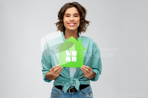 Image of smiling young woman holding green house