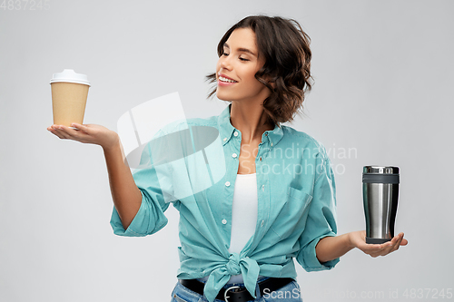 Image of woman comparing thermo cup and paper coffee cup