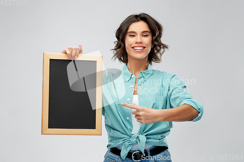 Image of portrait of smiling woman showing black chalkboard