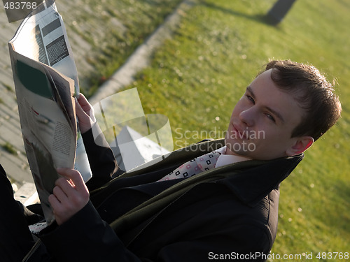 Image of Young businessman reading newspaper