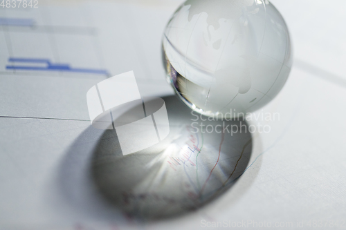 Image of Glass globe on stock market chart