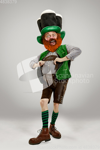 Image of Excited leprechaun in green suit with red beard on white background
