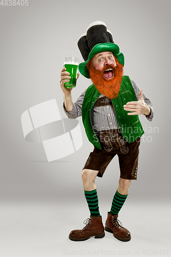 Image of Excited leprechaun in green suit with red beard on white background