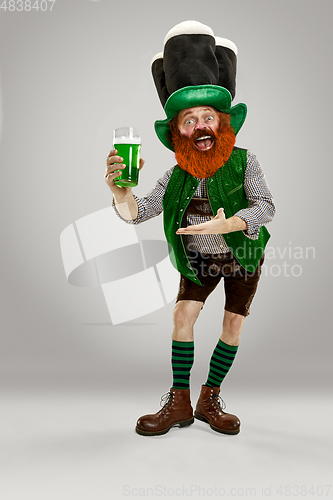 Image of Excited leprechaun in green suit with red beard on white background