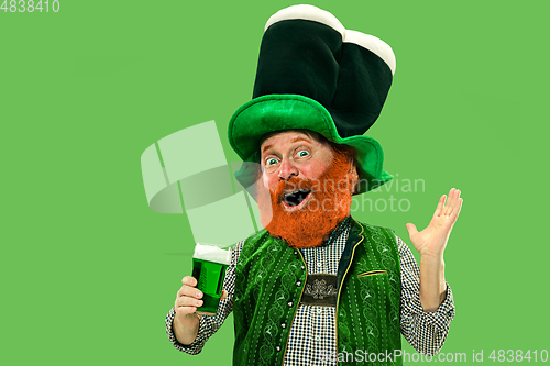 Image of Excited leprechaun in green suit with red beard on white background