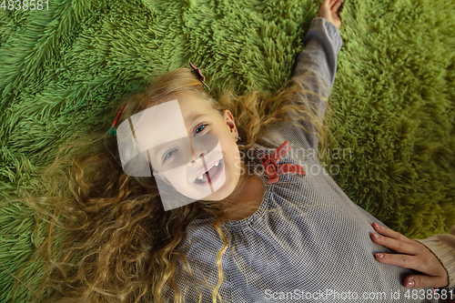 Image of Happy child, caucasian girl, daughter laying and laughting